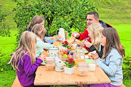Der Schweizer Tisch ist reich gedeckt: Familie macht Ferien auf einem Bauernhof.