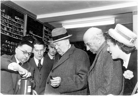 20. September 1946: Prominenter Besuch in der Farbenfabrik in Urdorf. Willy Sax (links) erklärte Sir Winston Churchill die Farbpresse. Der englische Premier verwendete als Hobbymaler selber Saxöl­farben und liess es sich nicht nehmen, die Produktion zu besuchen. 