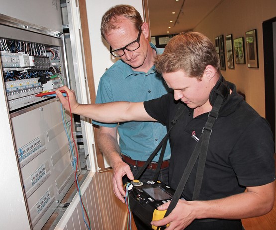 Un team de rêve: le chef expert Adrian Sommer et le jeune ­champion Daniel Gerber vérifient la sécurité du système électrique à l’aide d’un testeur d’installation. Photo: CR