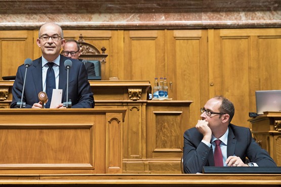 Le conseiller national Gregor Rutz (UDC/ZH) au pupitre lors du débat sur l’abolition des frais de Billag lors de la session d’automne 2017, sous le regard attentif de son collègue et néanmoins opposant, Martin Candinas (PDC/GR). Photo: dr