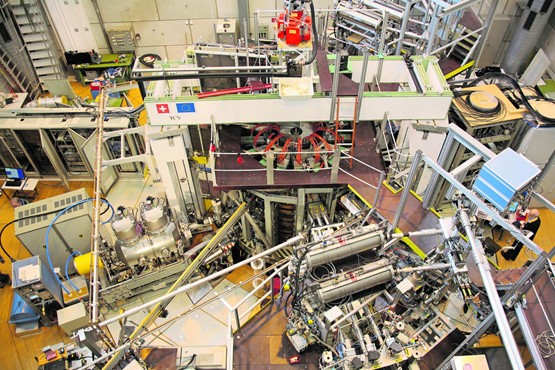 Le professeur Ambrogio Fasoli et le Tokamak à Lausanne (EPFL), devant une maquette de l’installation et une affiche montrant la chambre où le plasma est contenu,  la température dépassant celle du Soleil. La coopération internationale prend du temps, mais présente également des avantages politiques sur le long terme. PHOTO: OGI