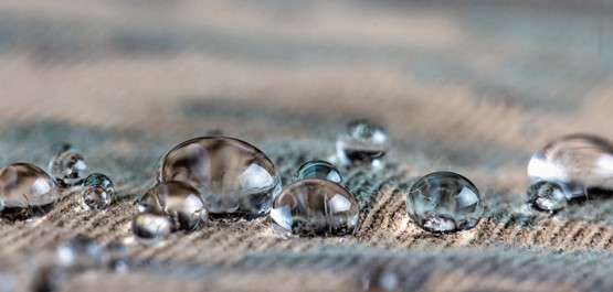 Auch das kann Nanotechnologie: Wassertropfen auf einem Feuchtigkeit abweisenden Tuch. Bild: Fotolia