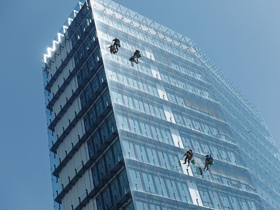Hommes araignées sur la tour de l‘OFS à Neuchâtel: comment jouer collectif dans une économie? Photo: Doris Vogt