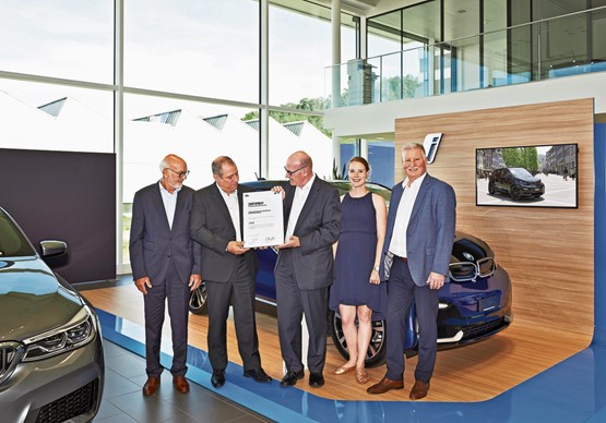 Ein Lob für nachhaltiges Wirtschaften: Garagier Markus Hutter (Mitte) nimmt das Zertifikat Goldstandard Green Building entgegen.Bild: zVg
