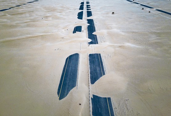 La route après une tempête de sable. Les robots jockeys permettant aux dromadaires de donner le meilleur d’eux-mêmes, comme les PME suisses à l’exportation. Savoir saisir sa chance…Photos: Unsplash