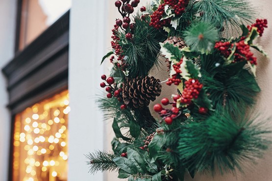 Festlicher Klassiker in Rot-grün: stilvoller Weihnachtskranz mit roten Beeren, Tannzapfen und Zweigen. Bild: 123RF