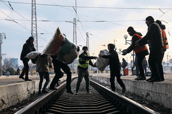 Alle packen nach Kräften mit an: Freiwillige Helfer transportieren medizinische Hilfsgüter über die Gleise im Bahnhof von Lwiw.Bild: Keystone