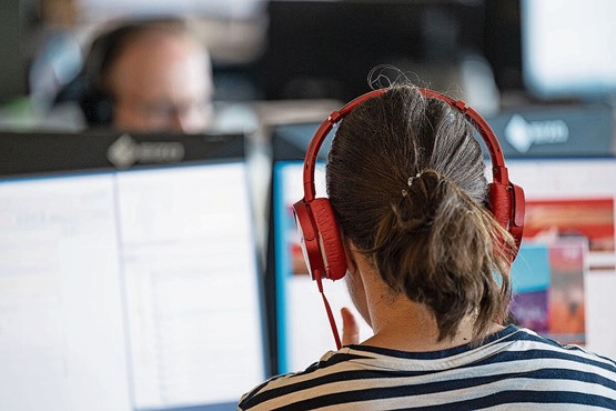 Même si les ambitions de carrière ont diminué, les employés en Suisse souhaitent se former et rester à la pointe du développement. À l’image de cette femme qui travaille avec des écouteurs dans un bureau «open space» à Berne.Photo: Keystone