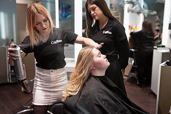 Mit einem Mindestlohn wird die Berufslehre aufs Spiel gesetzt, welche Garant für eine tiefe Jugendarbeitslosigkeit ist. Eine Coiffeur-Lehrtochter schneidet und frisiert Haare unter Aufsicht einer Lehrlingsbetreuerin.Bild: Keystone