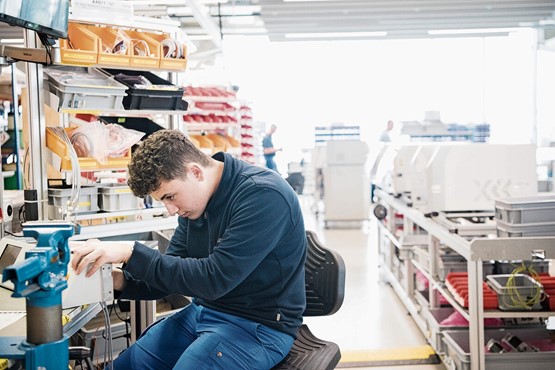 Die Woche der Berufsbildung richtet sich an Eltern und Jugendliche im Berufswahlalter sowie an alle, die sich für eine starke Berufsbildung engagieren. Ein Automatiker in Ausbildung arbeitet an der Vormontage einer Maschine.Bild: Keystone