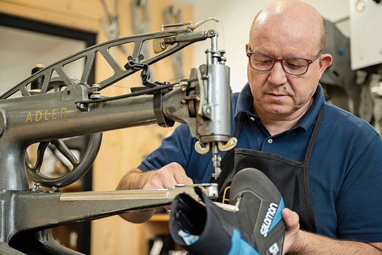 Orlando Rada setzt mit seiner Firma ganz auf das Thema Kreislaufwirtschaft. Was möglich ist, flicken er und seine Mitarbeiter. Das sind vor allem Neubesohlungen, aber auch eine aufgeplatzte Naht an einem Langlaufschuh ist für Orlando Rada eine Kleinigkeit.Bilder: Max Hugelshofer, Schweizer Berghilfe