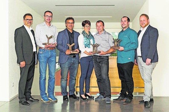 Die diesjährigen Preisträger von Holzbau Plus, flankiert von Stefan Strausak, Geschäftsführer der Schweizerischen Paritätischen Berufskommission Holzbau (r.), und Hans Rupli, Präsident von Holzbau Schweiz (l.).
