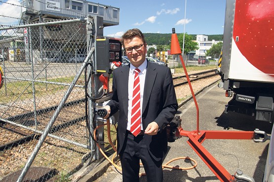 Der Coop-Nachhaltigkeitsverantwortliche Georg Weinhofer zeigt die Ladestation für die E-Trucks auf dem Gelände der Verteilzentrale in Dietikon (ZH). Der Elektro-Lkw kann aber auch unterwegs an jeder Industrie-Steckdose nachgeladen werden. Bild: B. Vogel