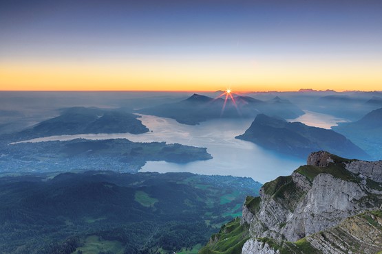 Offenheit, Flexibilität und Sicherheit machen die Schweiz zu einem Stern am Himmel: Blick vom Pilatus über den Vierwaldstättersee auf den Sonnenaufgang über dem Säntis.