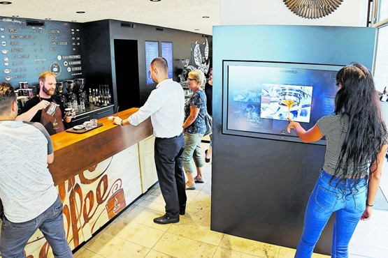 Neue Technologien in der Gastronomie: Auf dem riesigen Touchscreen können sich die Kunden mit Infos rund um den Shop eindecken. Bilder: André Albrecht